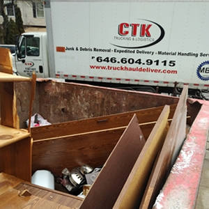 CTK trucking truck near a dumpster full of junk